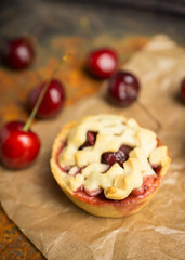Delicious cherry tartlets on the rustic background. Shallow depth of field.
