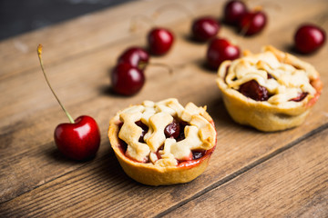 Delicious cherry tartlets on the rustic background. Shallow depth of field.