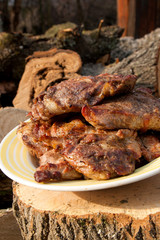 Juicy pork steaks cooked on an open flame grill on big white plate..