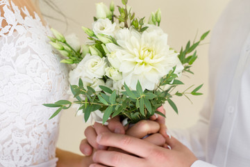 The bride and groom holding a wedding bouquet