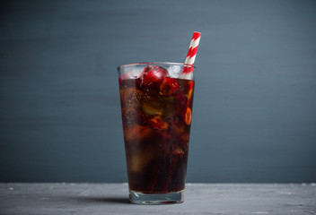 Refreshing cold cherry cola on the wooden background