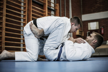 Two young males practicing judo together.