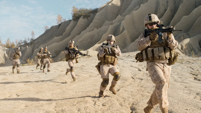 Squad of Fully Equipped, Armed Soldiers Running in the Desert. Show Motion.