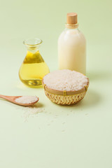 Rice oil in bottle glass and milk over green background.