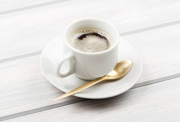 Cup of coffee with spoon sore wooden table.