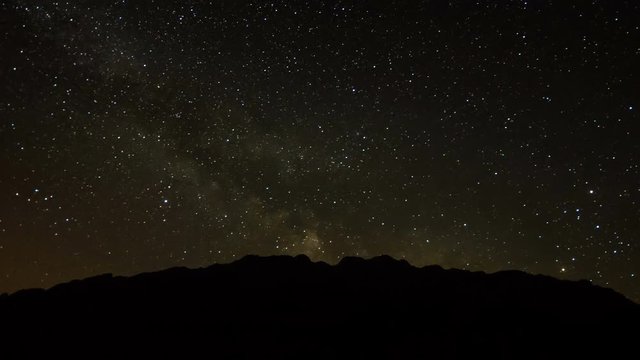 Night sky with meteor shower over the mountains silhouette.  Piatra Craiului, Romania. 4k timelapse.