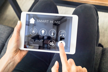 Person using smart home automation assistant on digital tablet computer