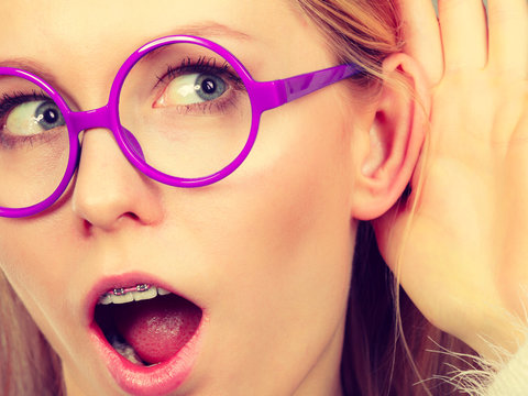 Woman listening carefully with hand close to ear