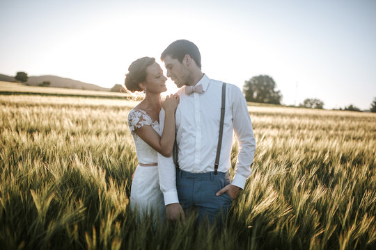 bride and groom standing in a field