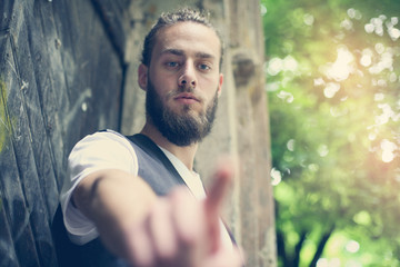 Man pointing to the index finger outdoor. Focus on man.
