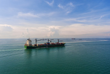 Obraz premium container ship in import export and business logistic.By crane , Trade Port , Shipping.Tugboat assisting cargo to harbor.Aerial view.