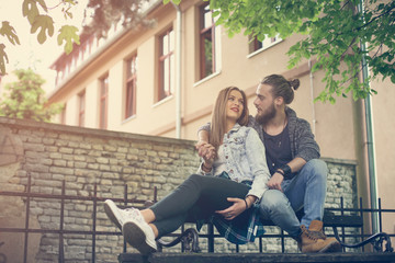 Obraz premium Young couple in the park. Couple sitting on the bench.