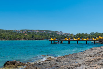 Beach and pier with yellow bean bag chairs at Cesme, Turkey