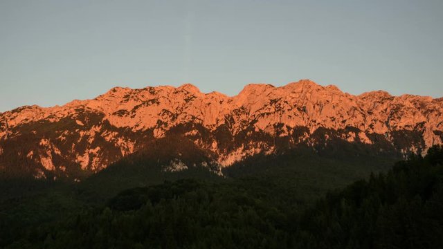 4k timelapse of sunset in Piatra Craiului  Mountains, Romania.  Red mountains becoming dark while sunset, shadows covering the forest.