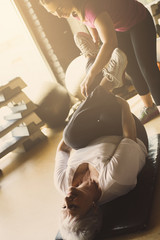 Fototapeta premium Senior woman workout in rehabilitation center. Personal trainer helping senior woman to do stretching exercise.