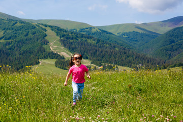 A little girl is running around the mountains