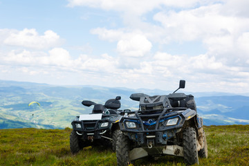 Fototapeta na wymiar Motorsport in the mountains. Two ATVs on top of a mountain