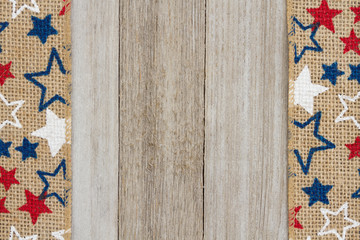 Red, white and blue stars burlap ribbon on weathered wood background