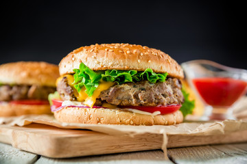 Classic hamburger with beef and sauce on dark background.