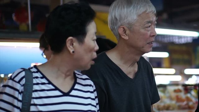 Asian senior couple shopping for food at local market of South East Asia