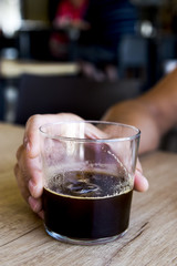 young man with an iced coffee in a coffeehouse