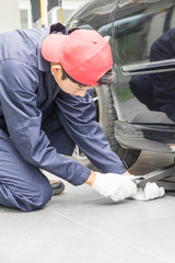 Mechanic replacing lug nuts changing tires on vehicle