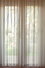 Translucent white curtains on the glass doors