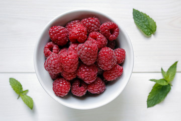 raspberries in a bowl on white background