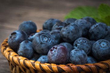 Arrangement Blueberries in wicker on old plank