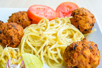 Spaghetti pasta with meatballs, tomato and peper powder, close up image.