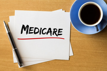 Medicare - handwriting on papers with cup of coffee and pen, health concept  