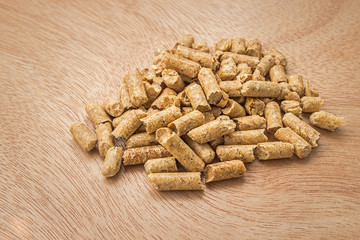 Wood pellets on a wooden background. Biofuels. Cat litter.