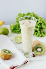 Fototapeta na wymiar Fresh smothie - vegan drink with banana, salad leaves, ginger and kiwi.