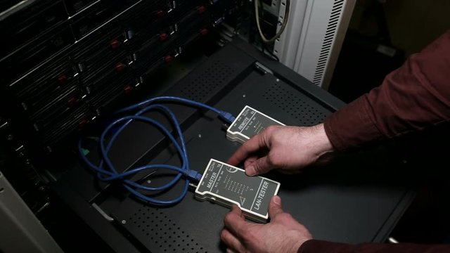 The person works with network cable LAN tester Full HD
