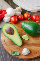 Avocado fruit on wooden board with other vegetables.