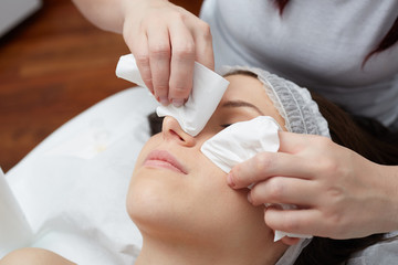  Relaxing beautiful woman having a massage for her skin on a face in beauty salon