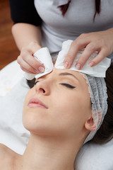  Relaxing beautiful woman having a massage for her skin on a face in beauty salon