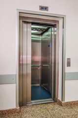 Elevator with new and modern cabin made of bright alloy and metal with modern elevator buttons