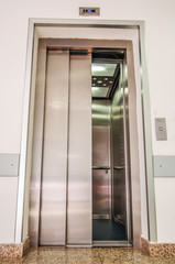 Elevator with new and modern cabin made of bright alloy and metal with modern elevator buttons