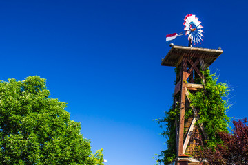 Red, White & Blue Weather Vane On Top Of Wooden Tower