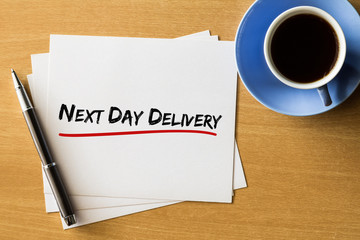 Next day delivery - handwriting on papers with cup of coffee and pen, business concept