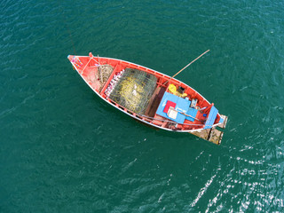 Fototapeta na wymiar Fishing boat floating in the sea. The beautiful bright blue water in a clear day.Aerial view.Top view.