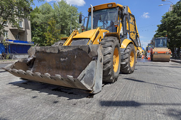 Obraz na płótnie Canvas Heavy construction bulldozer and vibrating roller during road construction.