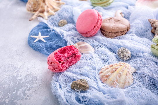 Assorted almond cookies macaroon with sea decoration on light gray stone background. Party food concept. Copy space.