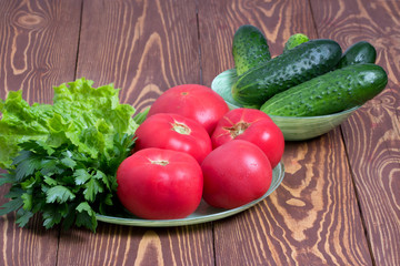 Свежие помидоры,огурцы и зелень на деревянном фоне