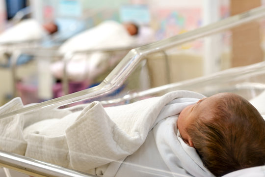 Newborn Babies In Nursery Area Of Hospital