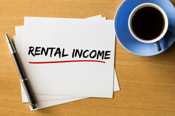 Rental Income - handwriting on papers with cup of coffee and pen, Business concept