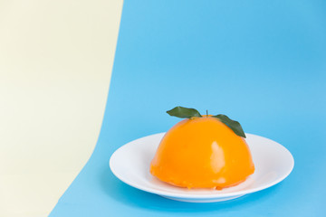orange cake on white plate with blue and yellow background