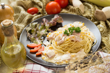 Delicious pasta carbonara with bacon and parmesan in a black bowl. homemade food style