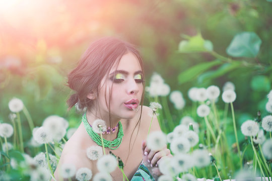 girl with fashionable makeup and beads in green leaves